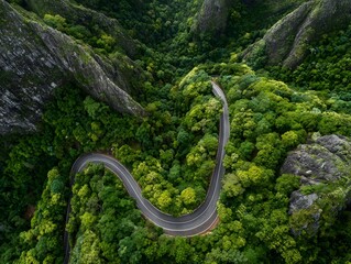Obraz premium Aerial view of winding road in forested mountains