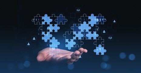 Digital puzzle pieces floating above a hand symbolizing global teamwork, collaboration, and success on a futuristic blue background.