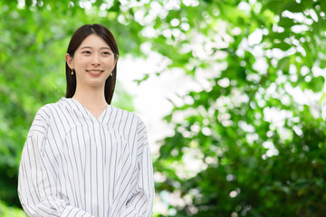 新緑の中に立つ女性
