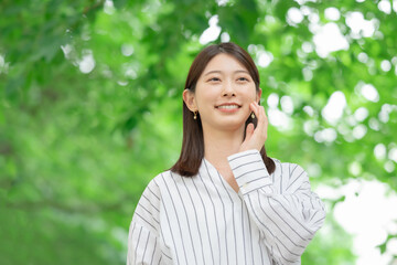 新緑の中に立つ女性