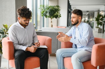 Psychologist taking notes while listening to patient talking about problems