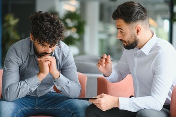 Psychologist supporting upset arab man during therapy session for ptsd
