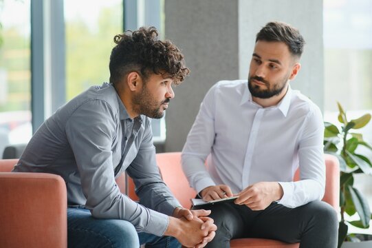 Psychologist supporting upset arab man during therapy session - Powered by Adobe