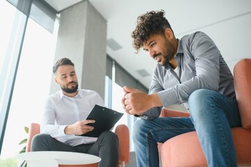 Upset arab man receiving psychological support from therapist