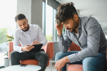 Upset arab man suffering from ptsd during therapy session with psychologist