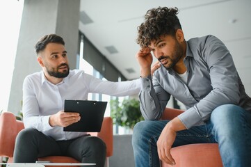 Psychologist comforting upset arab man during therapy session for ptsd