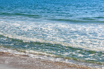 Tranquil ocean waves gently lapping sandy shore at sunny beach