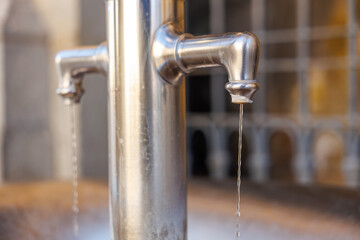 Stainless steel water tap with dual streams in urban public setting
