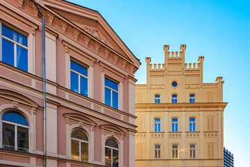 Historic european architecture with pink facade and yellow building against clear blue sky