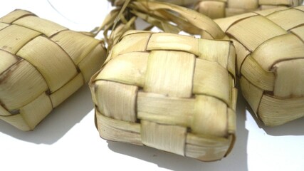Traditional ketupat woven from young coconut leaves, commonly served during Eid al-Fitr and festive celebrations in Indonesia. Cultural food background.