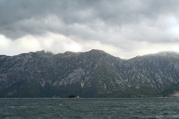Low clouds covering rocky green mountain slopes