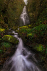 Naklejka premium Belaustegi waterfall inside a beech forest in the Gorbea Natural Park in Bizkaia at dawn