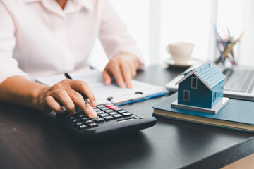 Calculator to check and summary expense of home loan mortgage for refinance plan , people lifestyle concept. Home agents are using calculator to calculate the loan period each month for customer.