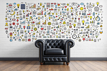 Black leather armchair against white brick wall with colorful business icons.