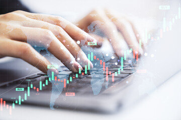 Female hands typing on laptop keyboard with forex candlestick chart, world map overlay, and buy-sell indicators on light background.