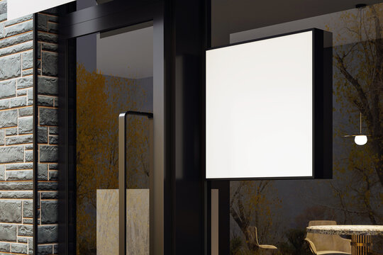 Blank illuminated square shop signage on modern storefront with glass door and brick wall facade at night in urban outdoor setting. 3D Rendering