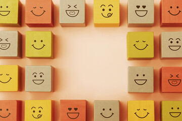 Happy Concepts. World Happiness Day, International Smiling Day. Mind and mental Health. Smiling Emoticon Face on Yellow Orange Cube. Table Top View with Copy space