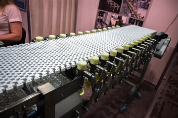 Close-up of a white modular plastic conveyor belt with yellow support rollers, part of an...