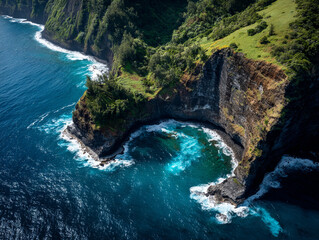 Fototapeta premium Aerial view of coastal cliffs and deep blue ocean waves crashing below