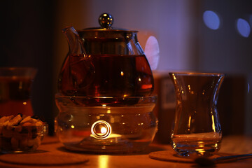 Cozy Evening with Tea Kettle, Glasses, and Snacks in Warm Light Setting