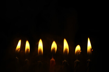 Row of Illuminated Candles Against Dark Background Creating a Calm and Peaceful Ambiance
