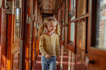 Girl strolls past polished panels in historic train corridor