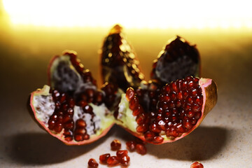 Close-Up of Fresh Pomegranate Fruit with Seeds Exposed and Illuminated Background