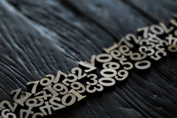 Wooden Numbers Spread Across Dark Textured Wood Background - Math Education Concept