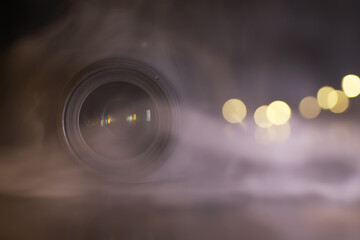 Close-Up of Camera Lens with Emerging Fog and Bokeh Background Lighting