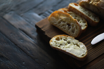 Sliced Rustic Bread with Butter on Wooden Cutting Board - Homemade Artisan Bread