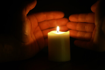 Hands Protecting Candle Flame in Darkness - Symbol of Hope, Safety, and Serenity