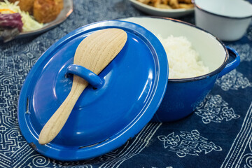 Blue Pot with Rice and Wooden Spoon on Tablecloth