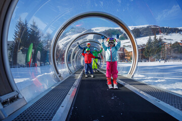 Family enjoys skiing adventure on a snowy ascend in lift tunnel