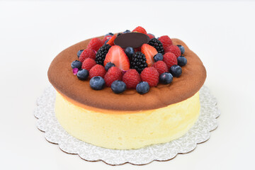 Fluffy Japanese Cheesecake topped with strawberries, raspberries, blueberries, and blackberries side view of delightful and popular dessert