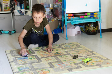 A 7-year-old boy plays with a car in the children's room