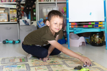 A 7-year-old boy plays with a car in the children's room