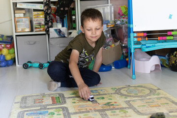 A 7-year-old boy plays with a car in the children's room