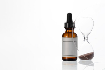 Abstract serum droplet bottle and crystal hourglass. Minimalist anti age beauty concept, sin modern cosmetic photography.