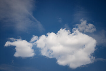 White clouds drifting across a deep blue sky on a sunny day