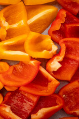 Sliced red and yellow bell peppers filling the frame, vibrant food background