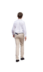 Fototapeta premium Adolescent vu de dos marchant en été, chemise blanche, pantalon beige et chaussures noires, tenue élégante et décontractée