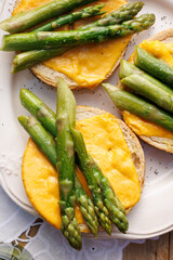 Asparagus open sandwiches with melted cheese, top view