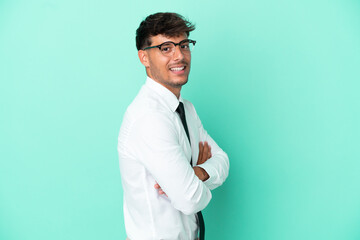 Business caucasian man isolated on blue background with arms crossed and looking forward