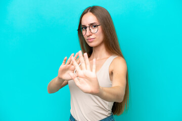 Fototapeta premium Young caucasian woman isolated on blue background nervous stretching hands to the front
