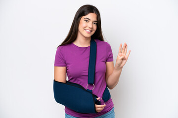 Young Brazilian woman with broken arm and wearing a sling isolated on white background happy and...