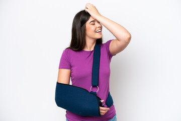 Young Brazilian woman with broken arm and wearing a sling isolated on white background has realized...