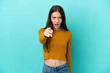 Young French woman isolated on blue background frustrated and pointing to the front
