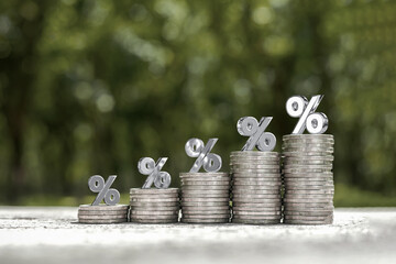 Money management, financial planning, and savings concepts. Percent symbol on stack of coins...