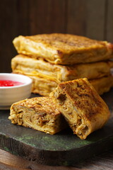Close up of savory Malaysian murtabak filled with minced beef and chicken served as traditional street food on a plate