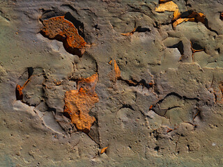 Close-up texture of rust and peeling paint on an old metal surface, showing decay, corrosion and...